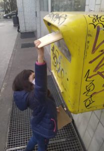 Inés echando la carta al buzón